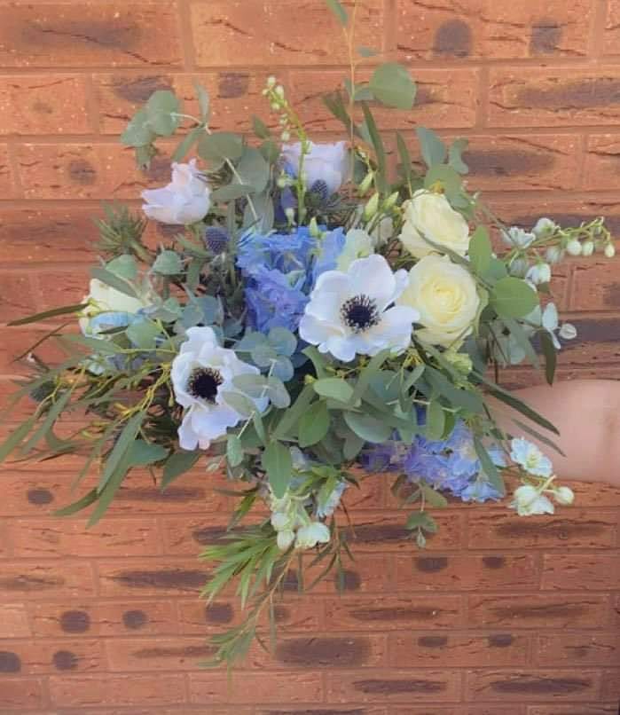Hand-tied bouquet of anemones and hydrangea in cool whites and blues, with texture and a little wildness