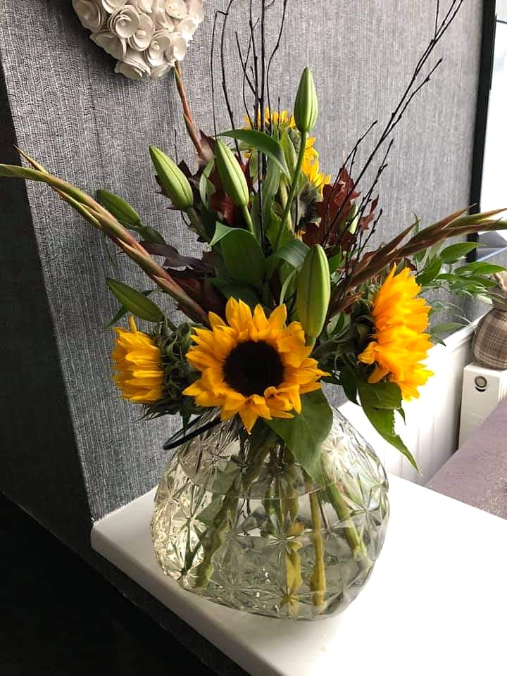 Sunflowers and lily buds in cut glass, bringing a little more of the outside in